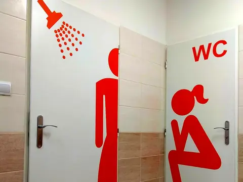 Červené piktogramy WC vyrezané z fólie na dverách