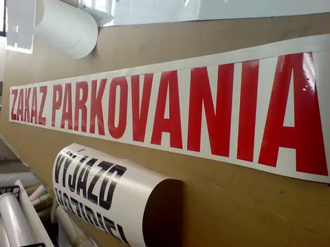 Červený vyrezaný nápis na nosnej fólii