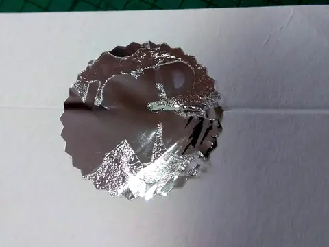 Strieborná okrúhla VOID plomba po pokuse o odlepenie