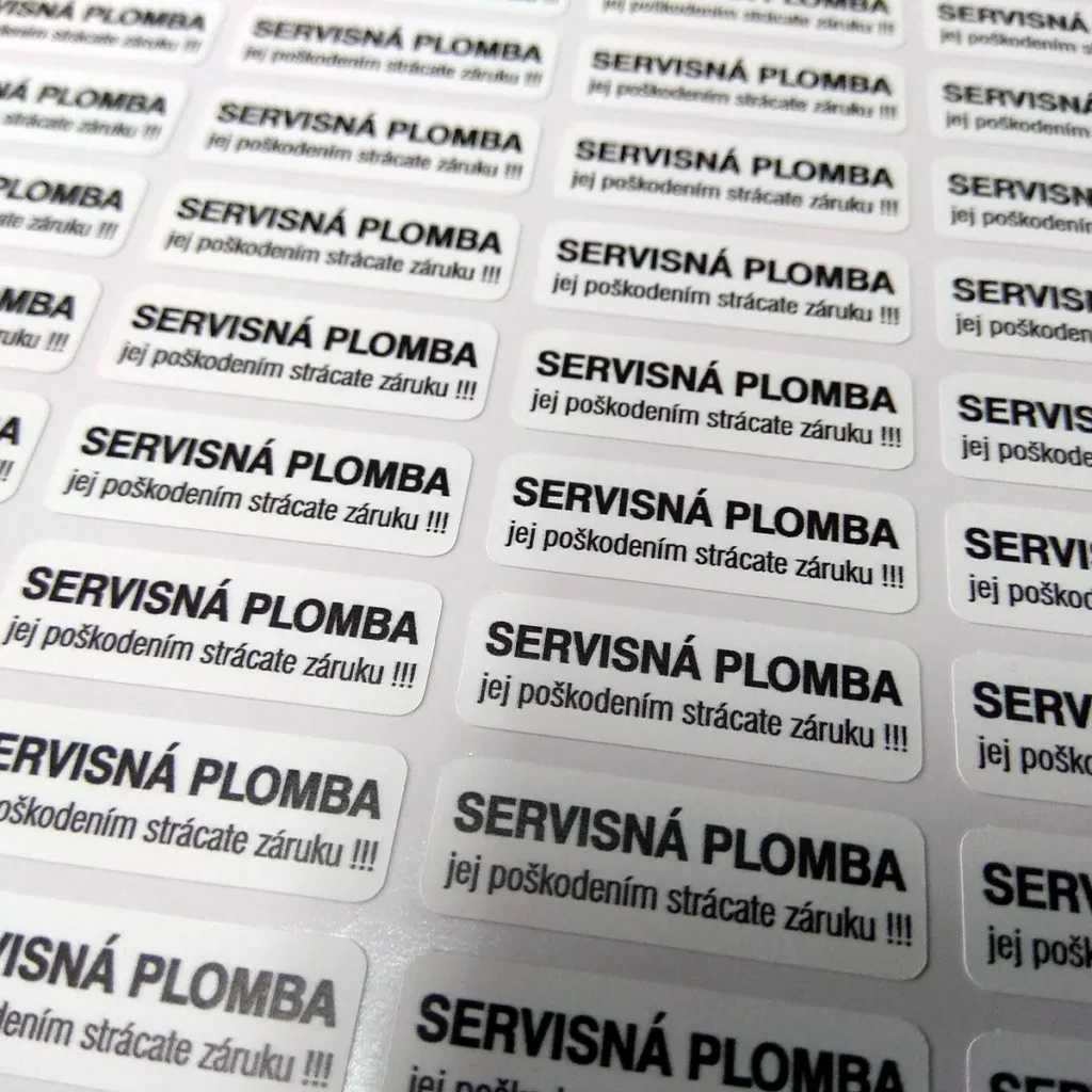 Hárok bielych destrukčných nálepiek s textom Servisná plomba – jej poškodením strácate záruku