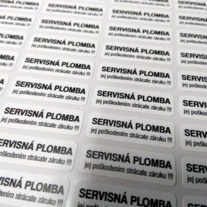 Hárok bielych destrukčných nálepiek s textom Servisná plomba – jej poškodením strácate záruku